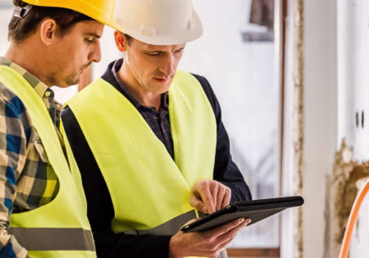  Plumber using a tablet with managed IT services interface in the background.